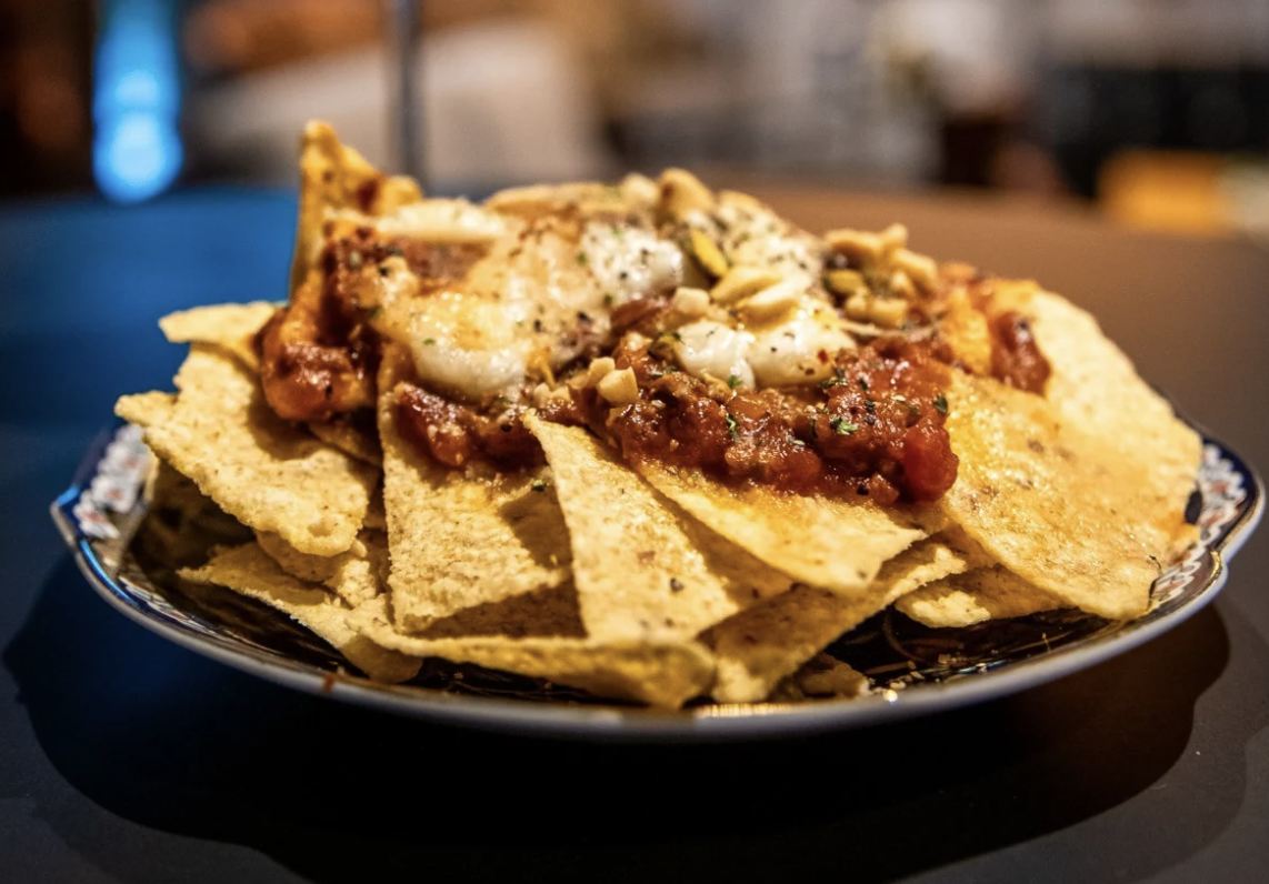 Nachos topped with melted cheese, meat, and sour cream at A Bunch of Coffee Tokyo